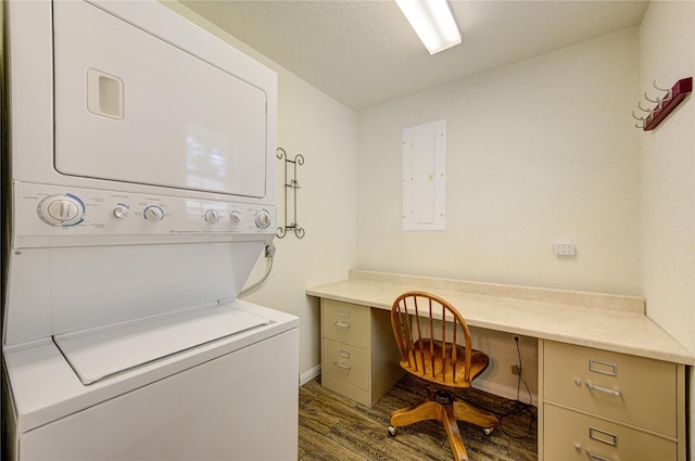 clothes washing area featuring stacked washer and dryer, dark wood-type flooring, electric panel, and a textured ceiling