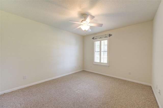 carpeted spare room featuring ceiling fan and a textured ceiling