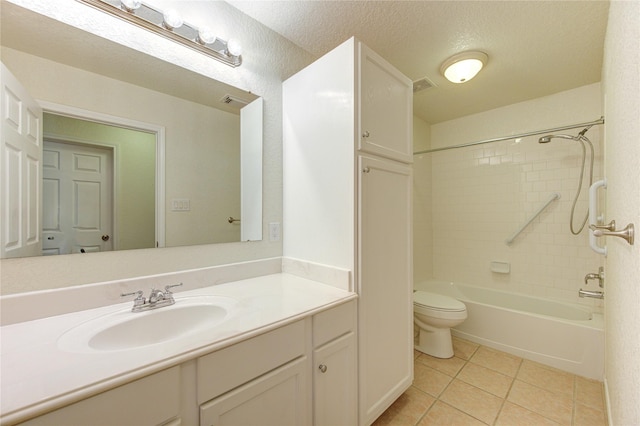 full bathroom featuring toilet, tiled shower / bath, a textured ceiling, vanity, and tile patterned flooring