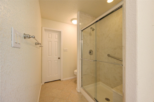 bathroom featuring toilet, tile patterned floors, a textured ceiling, and walk in shower