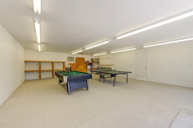 recreation room featuring a wall mounted air conditioner, pool table, and a textured ceiling