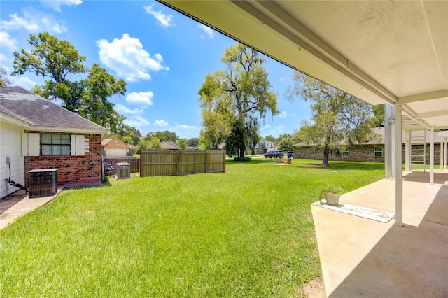 view of yard with central AC unit and a patio area