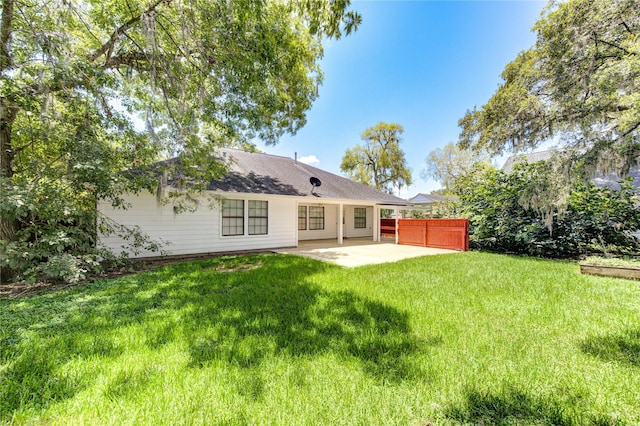 rear view of property with a patio and a lawn