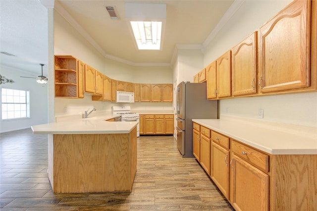 kitchen with crown molding, white appliances, kitchen peninsula, and light hardwood / wood-style flooring