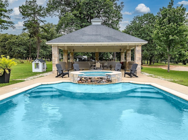 view of pool with a gazebo, a patio area, an in ground hot tub, and a lawn