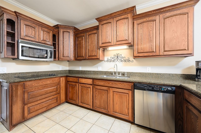 kitchen with light tile patterned flooring, appliances with stainless steel finishes, dark stone counters, and sink