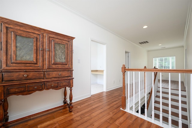 hallway featuring hardwood / wood-style floors and ornamental molding