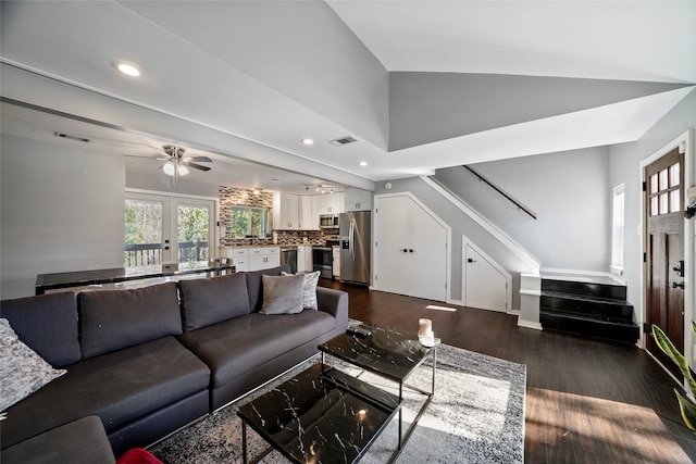 living room featuring ceiling fan, dark hardwood / wood-style flooring, and vaulted ceiling