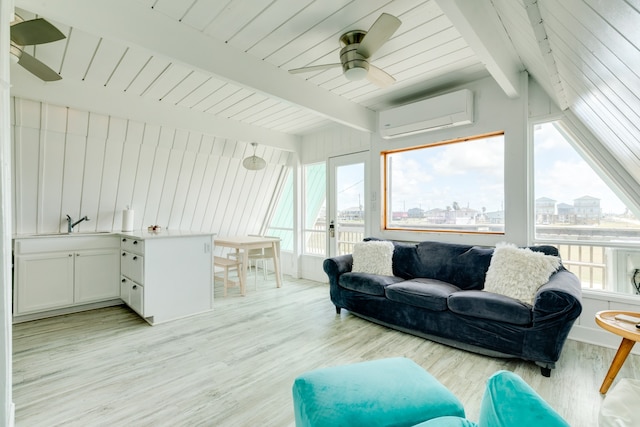 living room with ceiling fan, beam ceiling, light hardwood / wood-style floors, and a wall mounted AC