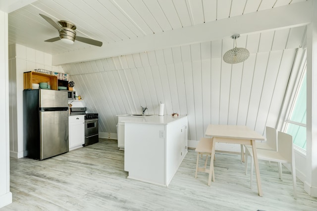 kitchen featuring light wood-type flooring, appliances with stainless steel finishes, white cabinets, decorative light fixtures, and ceiling fan