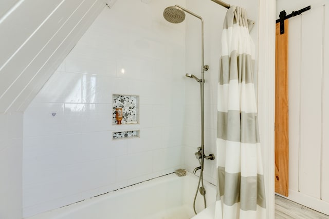 bathroom with hardwood / wood-style floors and shower / bath combo with shower curtain