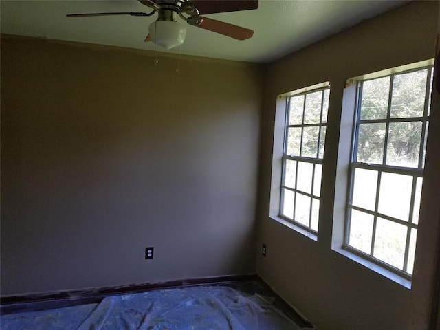 empty room with ceiling fan and a healthy amount of sunlight