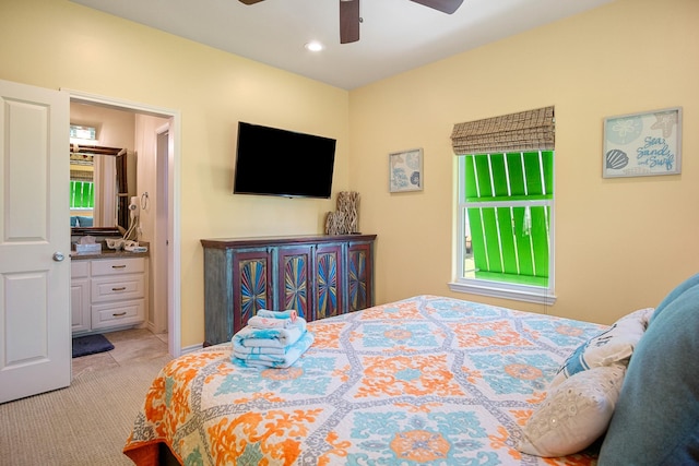 bedroom featuring ensuite bath, ceiling fan, and light colored carpet