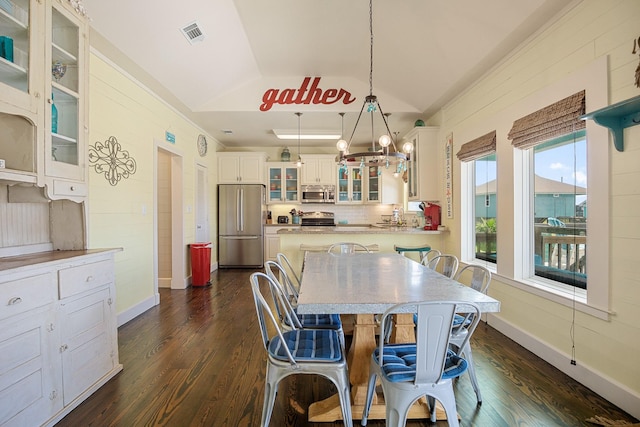 122 Ocean View Dr, Crystal Beach, TX 77650 - dining room featuring lofted ceiling, dark wood finished floors, baseboards, and a chandelier