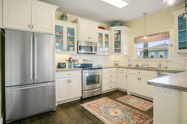 kitchen with stainless steel appliances, white cabinetry, and sink