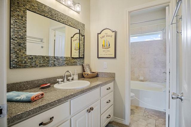 full bathroom featuring tiled shower / bath combo, vanity, and toilet