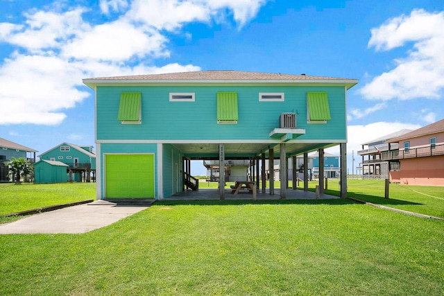 back of house featuring a garage, a carport, and a lawn