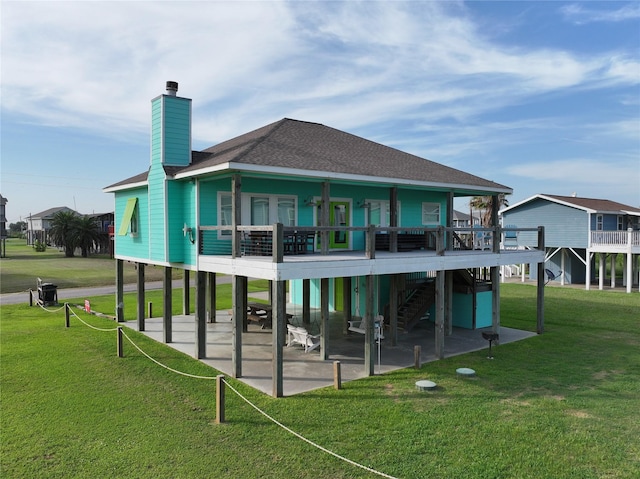 rear view of house featuring a patio area, a deck, and a lawn