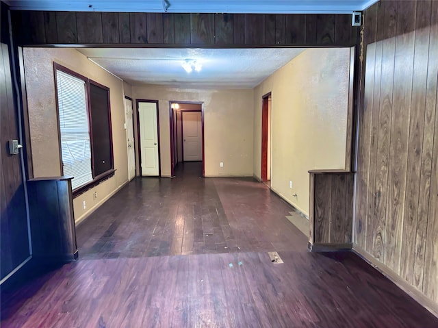 empty room with dark hardwood / wood-style floors and wood walls