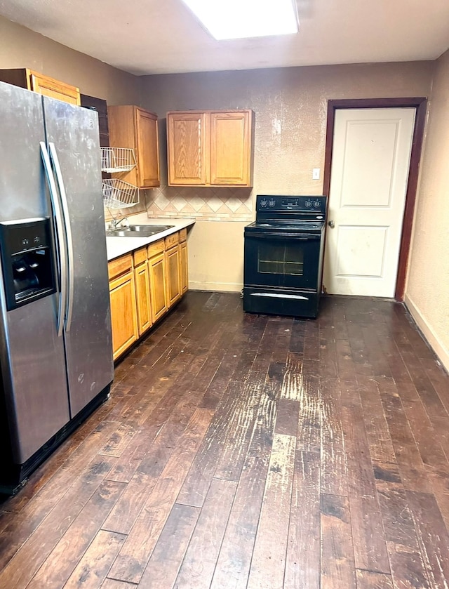 kitchen with dark hardwood / wood-style floors, black electric range oven, stainless steel refrigerator with ice dispenser, sink, and tasteful backsplash