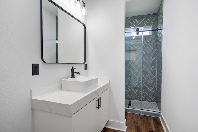 bathroom featuring vanity, hardwood / wood-style floors, and a shower with door