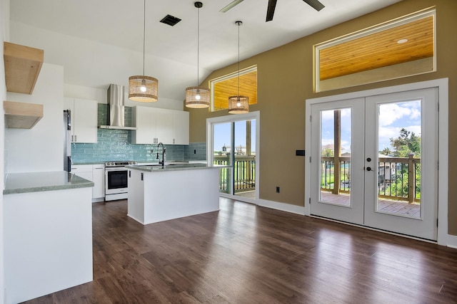 kitchen featuring french doors, wall chimney exhaust hood, hanging light fixtures, white electric stove, and white cabinets