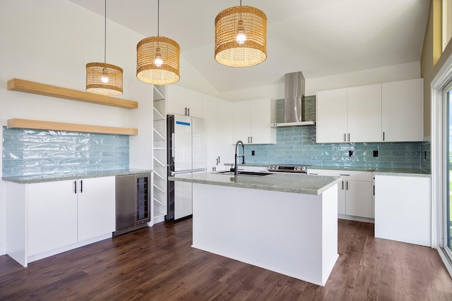 kitchen featuring white cabinets, beverage cooler, hanging light fixtures, white fridge, and wall chimney exhaust hood