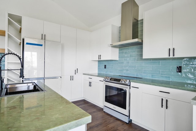 kitchen with electric stove, wall chimney range hood, sink, white cabinetry, and vaulted ceiling