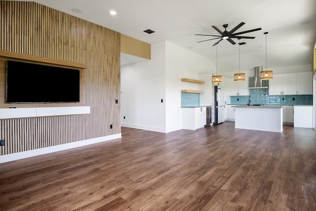 unfurnished living room with sink, dark hardwood / wood-style floors, and ceiling fan