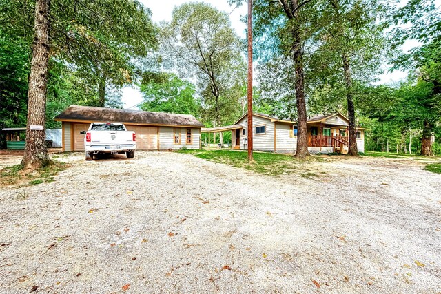 ranch-style home with a garage, an outdoor structure, and a porch