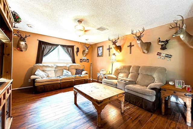 living room featuring ceiling fan, hardwood / wood-style floors, and a textured ceiling