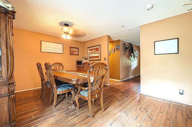 dining space with ceiling fan, wood-type flooring, and a textured ceiling