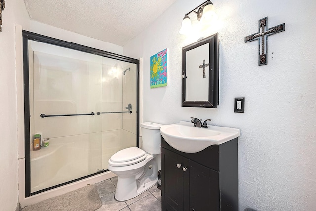 bathroom with a shower with door, vanity, a textured ceiling, tile patterned floors, and toilet