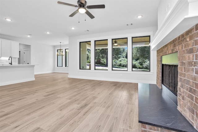 651 Paradise Dr, Coldspring, TX 77331 - unfurnished living room with a ceiling fan, a fireplace, light wood finished floors, recessed lighting, and baseboards
