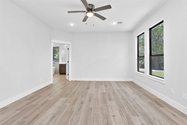 empty room with ceiling fan, plenty of natural light, and light wood-type flooring