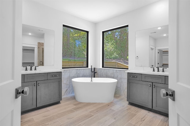 bathroom featuring vanity, plus walk in shower, and tile walls