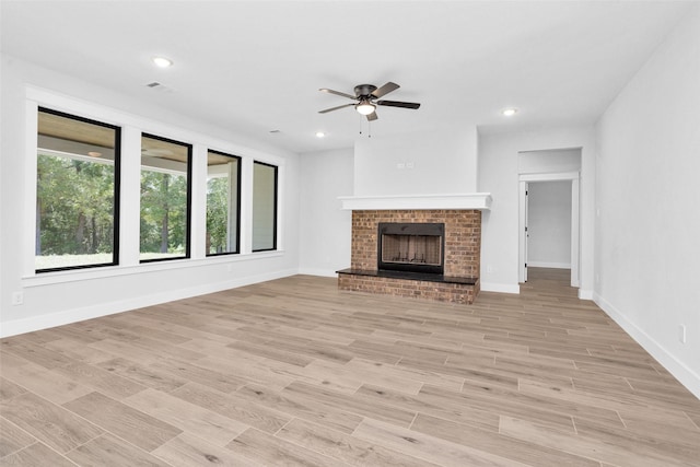 651 Paradise Dr, Coldspring, TX 77331 - unfurnished living room with ceiling fan, a brick fireplace, baseboards, light wood-style flooring, and recessed lighting
