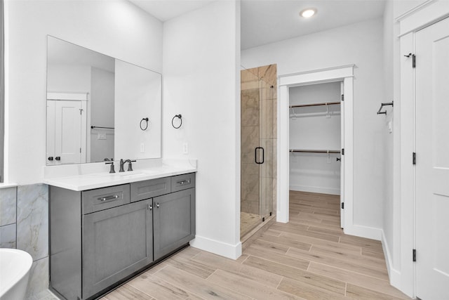 651 Paradise Dr, Coldspring, TX 77331 - full bath with a stall shower, a walk in closet, vanity, wood finished floors, and a freestanding bath