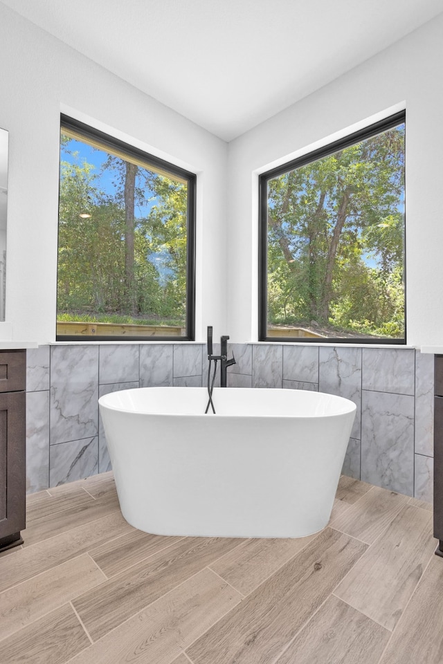 bathroom featuring a tub and tile walls