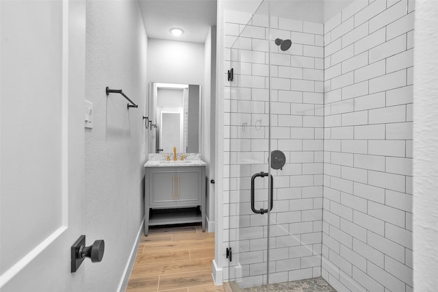 651 Paradise Dr, Coldspring, TX 77331 - bathroom featuring a shower stall, wood finished floors, a textured wall, vanity, and baseboards