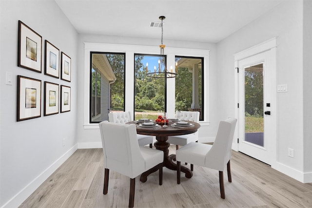 651 Paradise Dr, Coldspring, TX 77331 - dining area with a chandelier, light wood-style floors, and baseboards