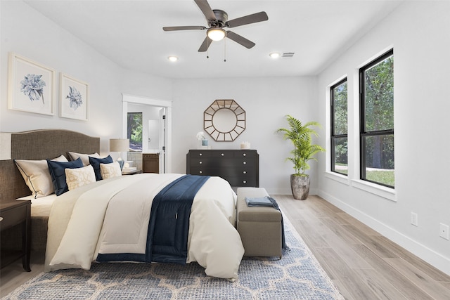 bedroom featuring multiple windows, light hardwood / wood-style floors, and ceiling fan