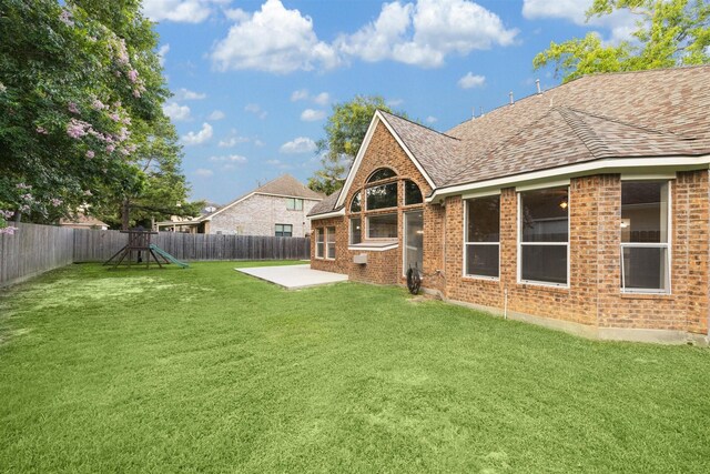 view of yard featuring a playground and a patio area