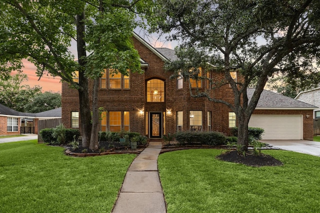 traditional-style house featuring a lawn, brick siding, driveway, and a shingled roof