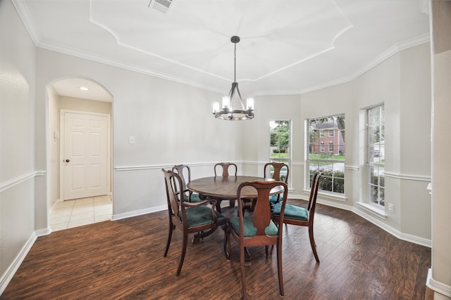 dining area featuring a notable chandelier, hardwood / wood-style floors, and crown molding