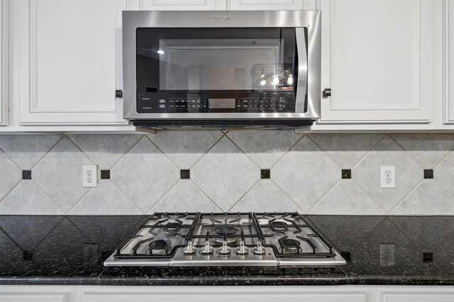 kitchen featuring appliances with stainless steel finishes, white cabinets, and tasteful backsplash