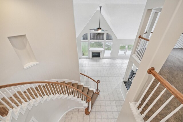 stairs with high vaulted ceiling, carpet flooring, and ceiling fan