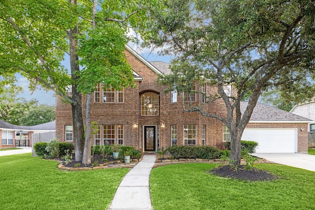 traditional-style home with driveway, a shingled roof, a front lawn, a garage, and brick siding