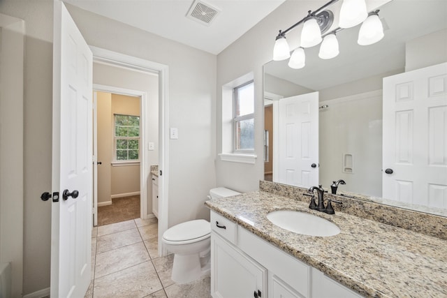 bathroom featuring tile flooring, plenty of natural light, oversized vanity, and toilet