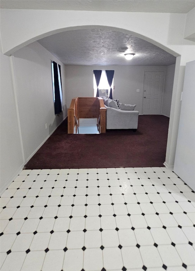 unfurnished bedroom featuring a textured ceiling and light colored carpet